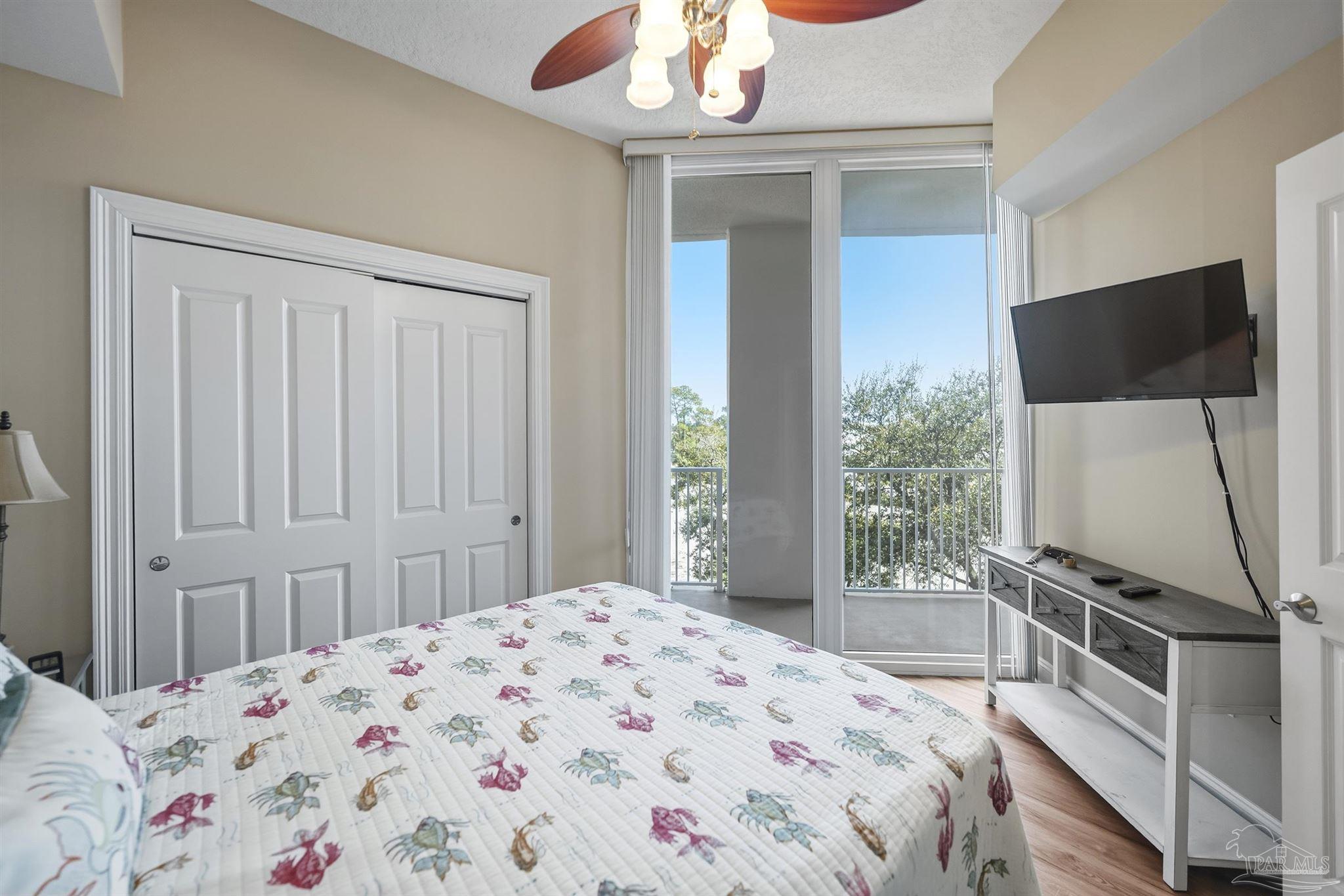 28250 Canal Road, Unit 205 Orange Beach, AL 36561 - Photo 26 of 60 a bedroom with a bed and a flat tv screen on the dresser