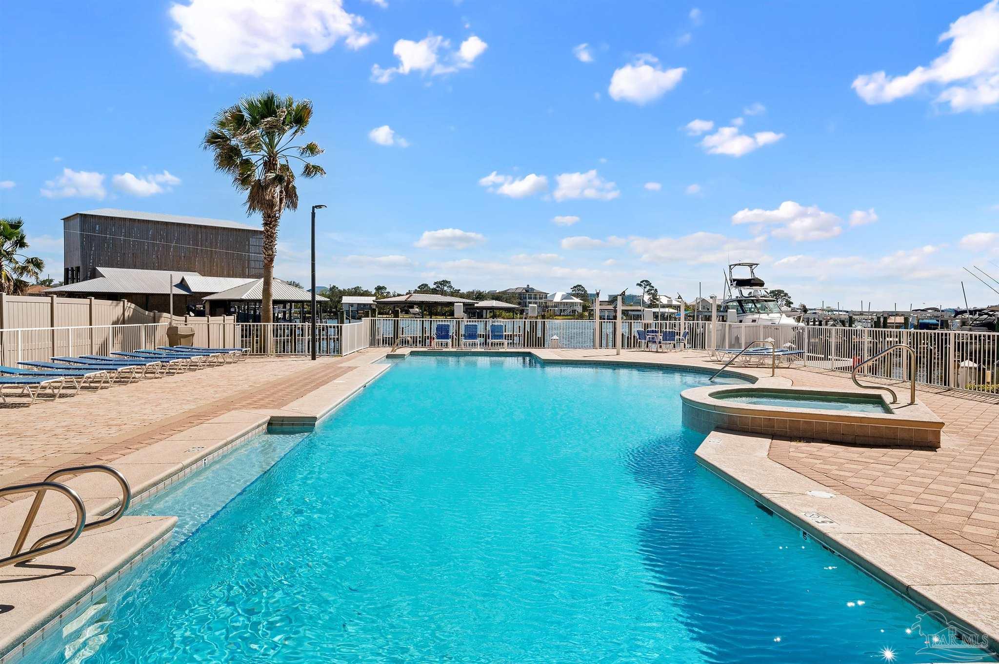 28250 Canal Road, Unit 205 Orange Beach, AL 36561 - Photo 37 of 60 a view of a swimming pool with a table & chairs