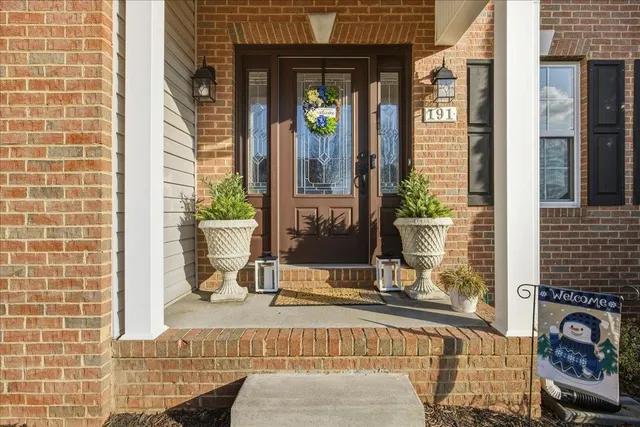 a view of a hallway with couches a fireplace with wooden floor