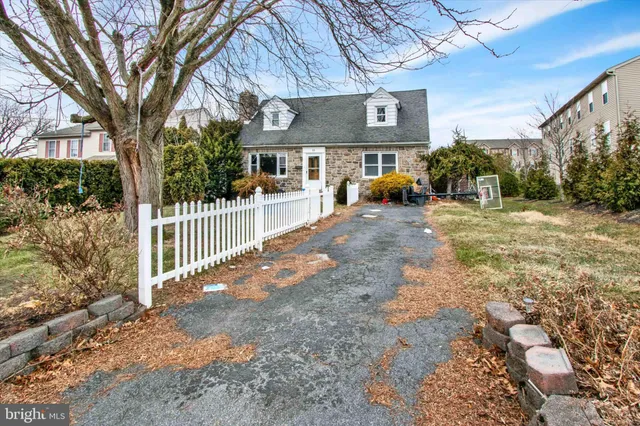 a view of a brick house next to a yard with plants and trees