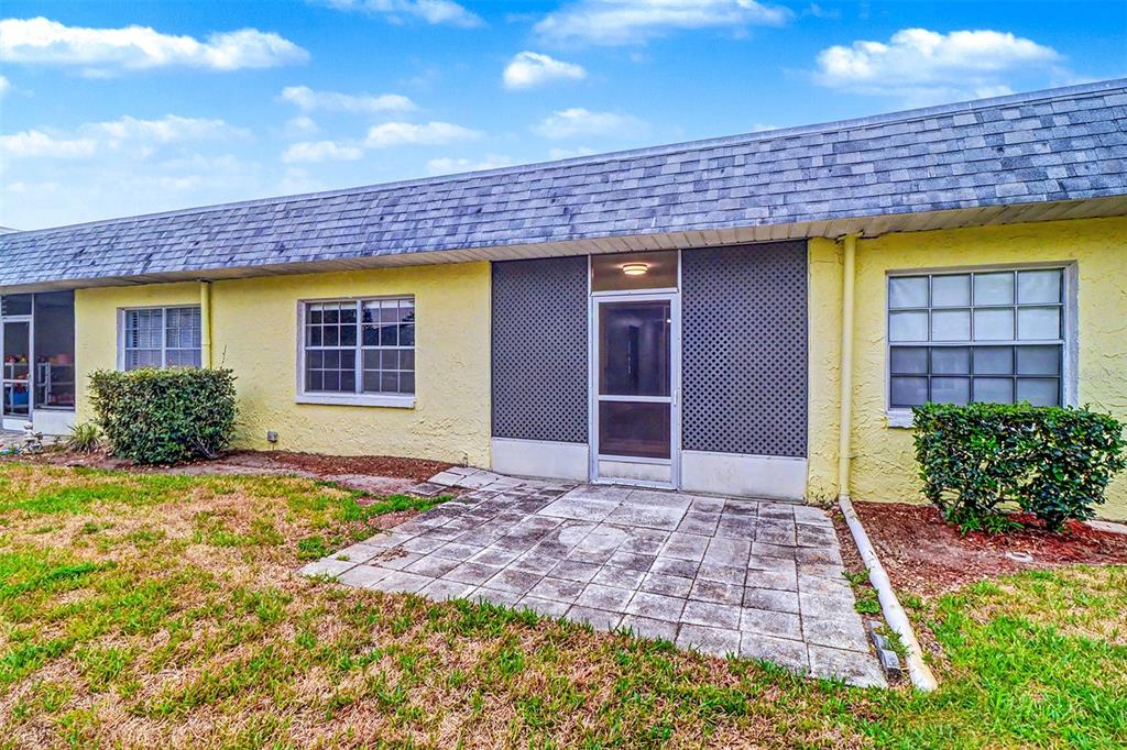 3661 Trophy Boulevard, Unit 3661 New Port Richey, FL 34655 - Photo 18 of 25 a view of a brick house with plants and a bench