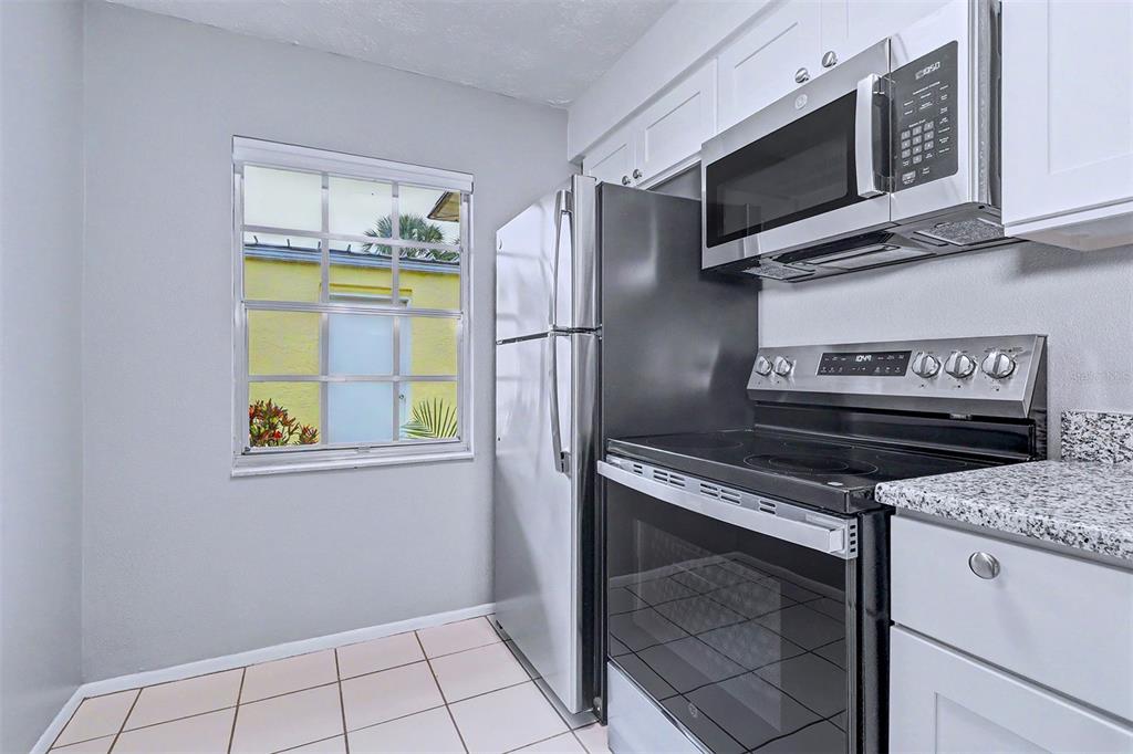 3661 Trophy Boulevard, Unit 3661 New Port Richey, FL 34655 - Photo 4 of 25 a kitchen with a stove microwave and refrigerator