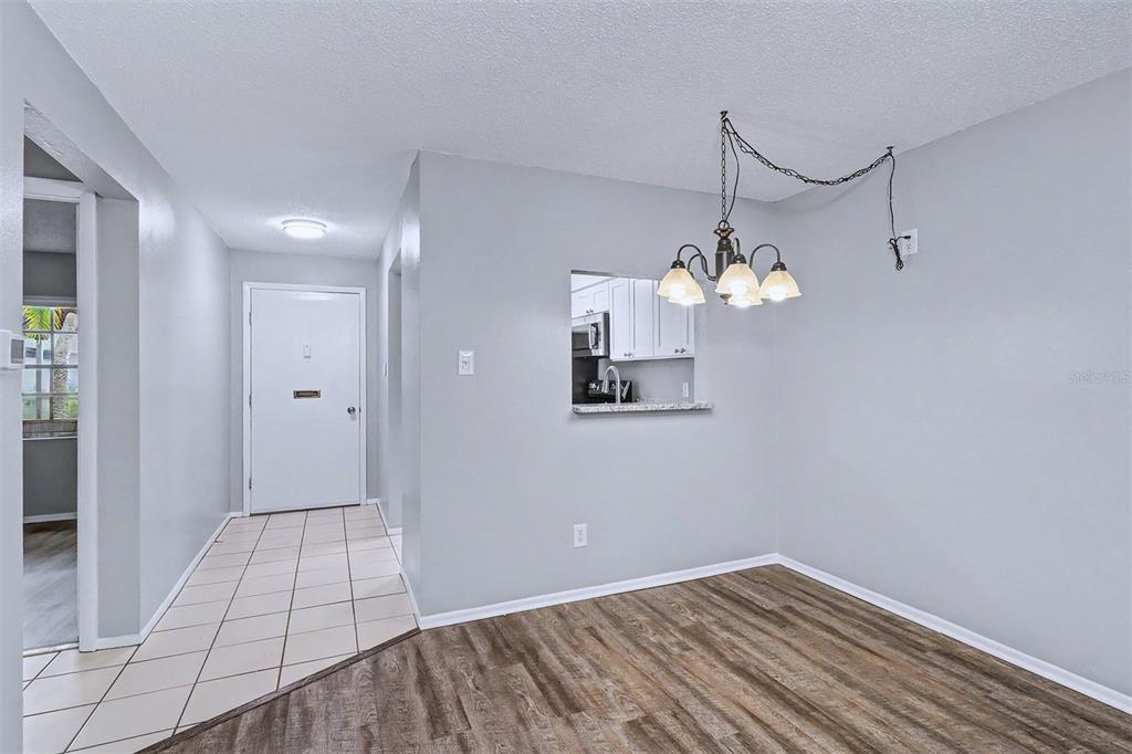3661 Trophy Boulevard, Unit 3661 New Port Richey, FL 34655 - Photo 9 of 25 a view of a room with wooden floor and chandelier