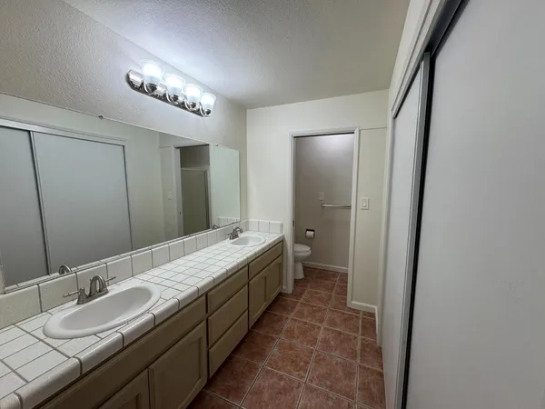 a spacious bathroom with a double vanity sink and a mirror