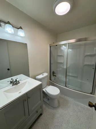a bathroom with a sink toilet a mirror and shower