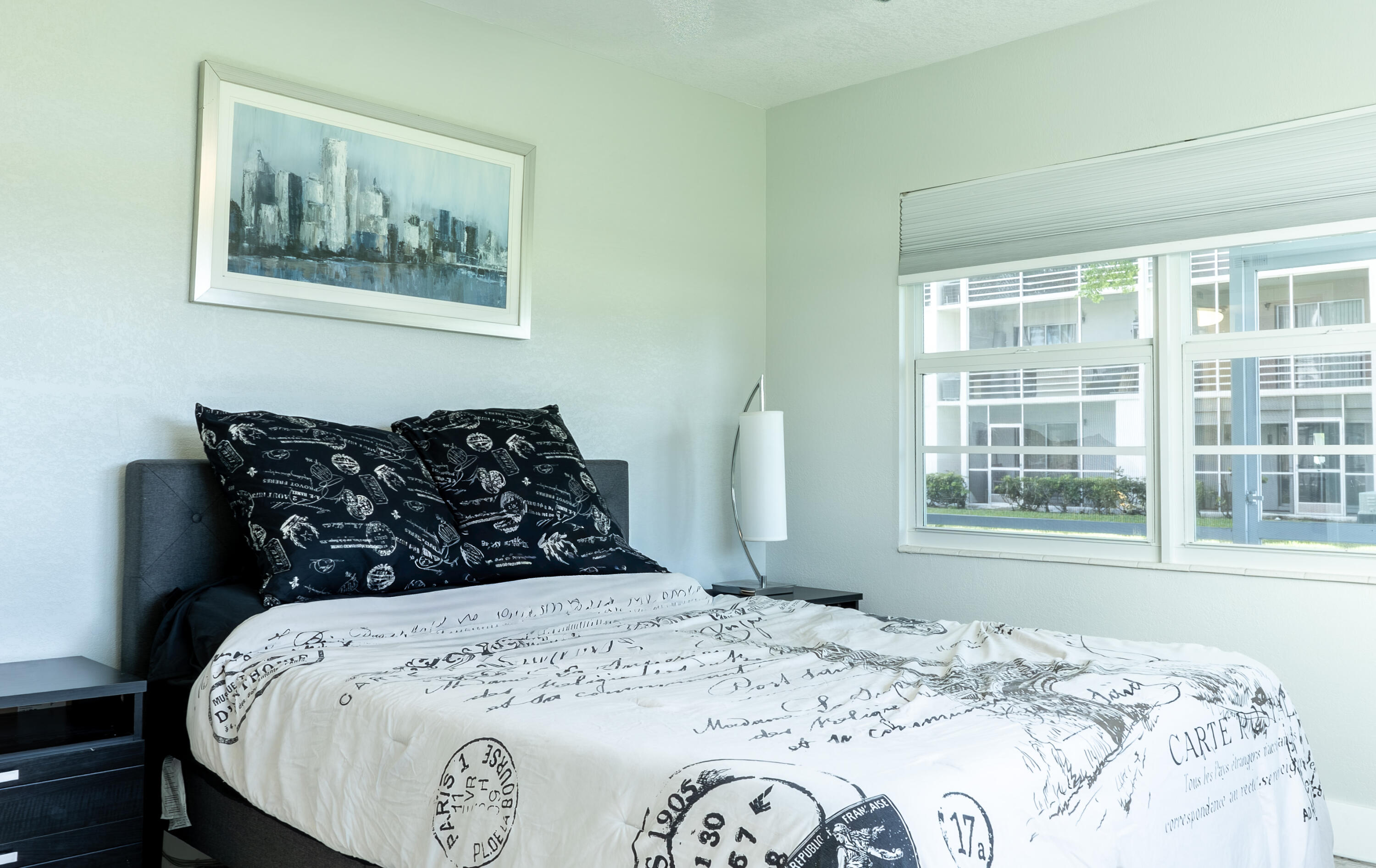 592 Fanshaw O Boca Raton, FL 33434 - Photo 12 of 26 a bed sitting in a bedroom next to a window with a large bed