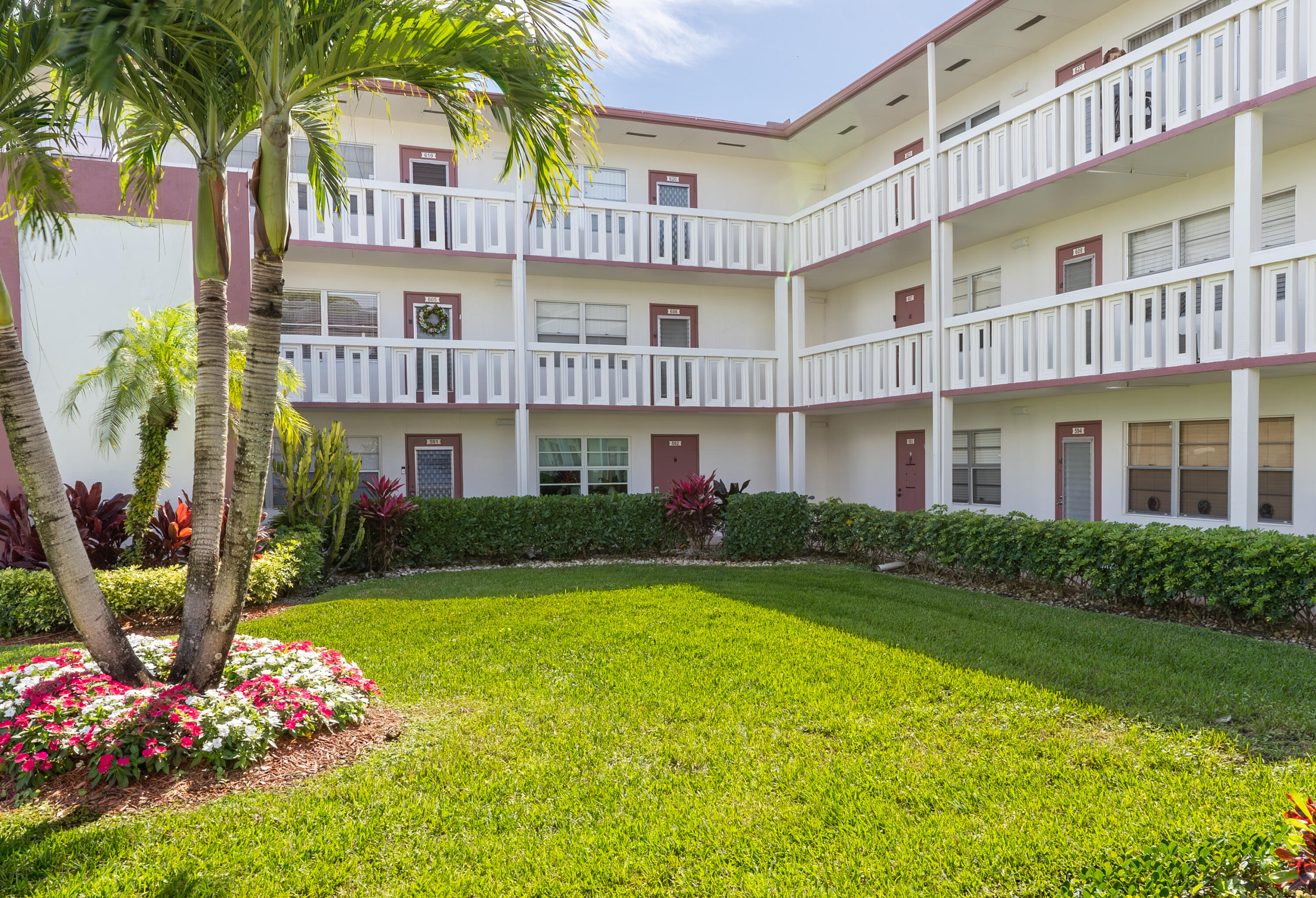 592 Fanshaw O Boca Raton, FL 33434 - Photo 9 of 26 a front view of a residential apartment building with a yard