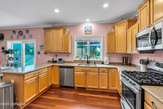 a kitchen with stainless steel appliances granite countertop a stove a sink and a microwave
