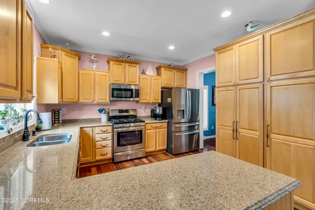 a kitchen with stainless steel appliances granite countertop a refrigerator stove top oven a sink and dishwasher