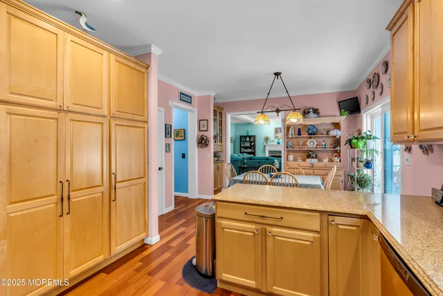 a room with kitchen island a counter top space and a wooden floor