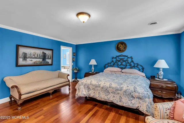 a bedroom with a bed and a lamp on dresser