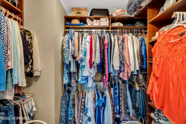 a view of walk in closet with clothes