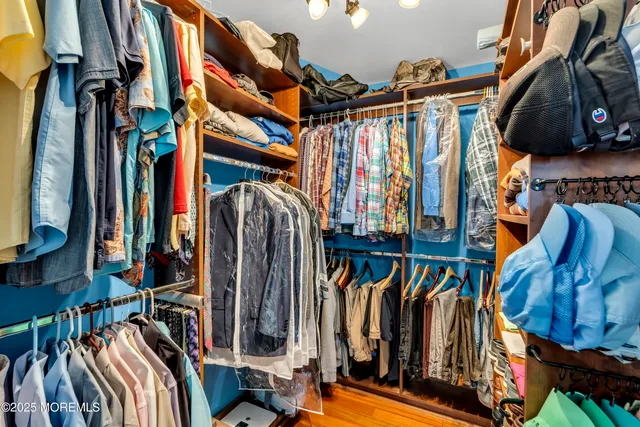 a view of walk in closet with clothes and shoes