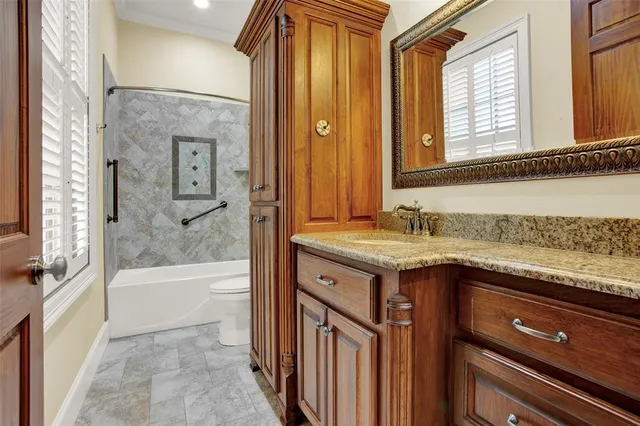 a bathroom with a granite countertop sink a mirror and a bathtub