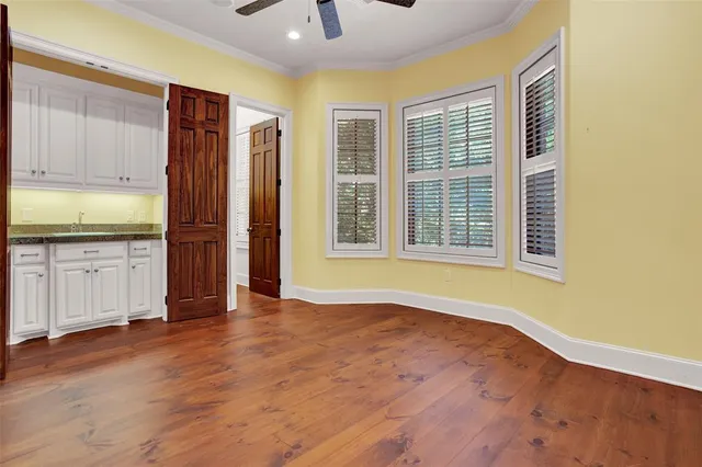 a view of an empty room with a window and wooden floor