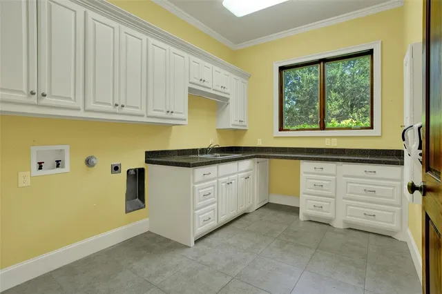 a kitchen with granite countertop white cabinets and window
