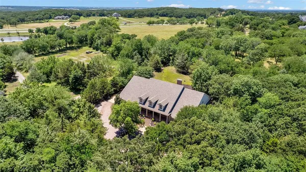 an aerial view of a house with a yard and lake view