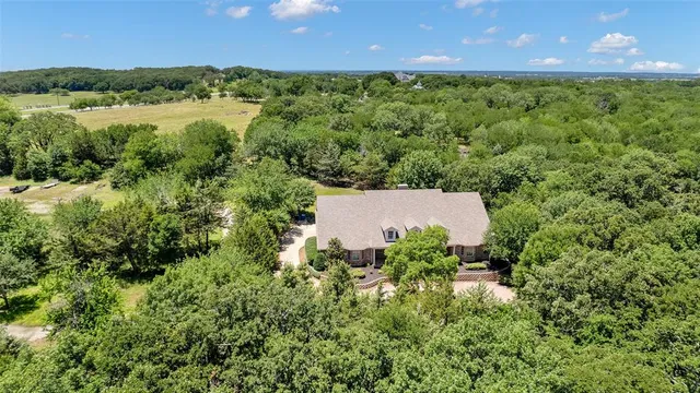 an aerial view of a house with a yard and lake view