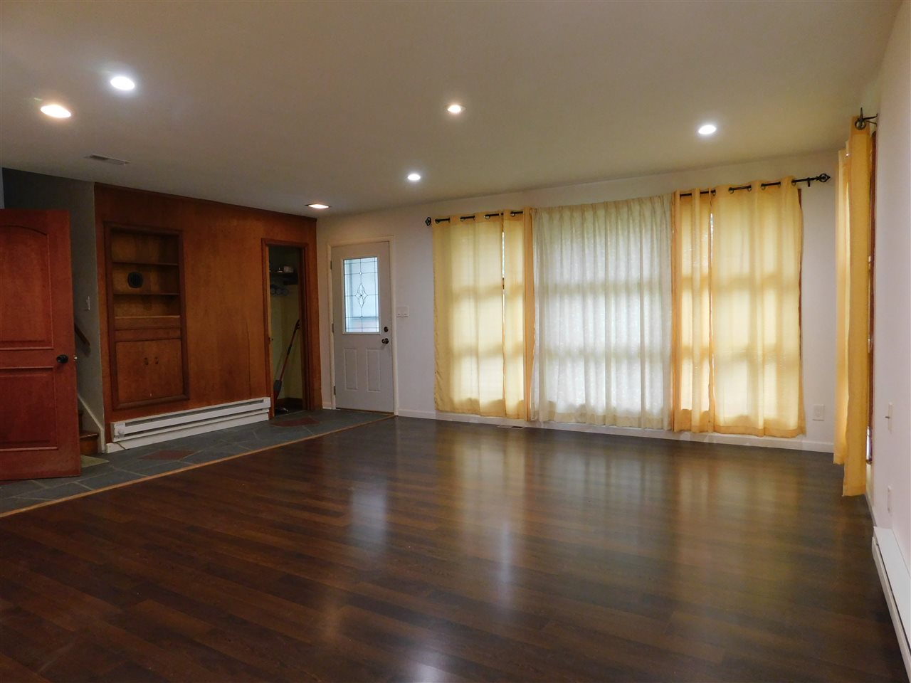 6309 Park Ridge Road Loves Park, IL 61111 - Photo 2 of 26 an empty room with wooden floor and windows with curtains