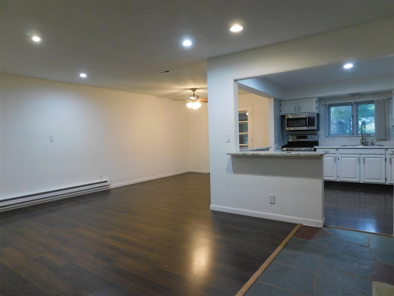 6309 Park Ridge Road Loves Park, IL 61111 - Photo 3 of 26 an empty room with wooden floor and kitchen view