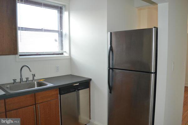 1018 North Charles Street, Unit R7 Baltimore, MD 21201 - Photo 7 of 13 a kitchen with a sink a refrigerator and window