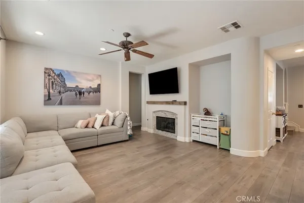 a living room with furniture a flat screen tv and a fireplace