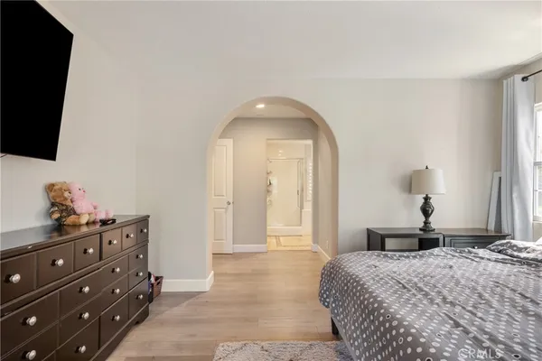 a bedroom with a bed and a flat tv screen on dresser