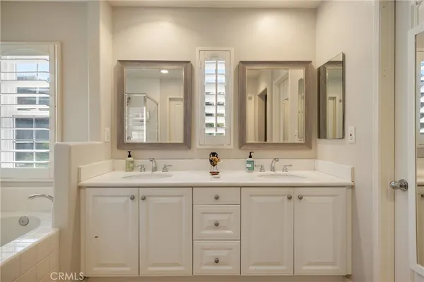 a bathroom with double sink and a mirror