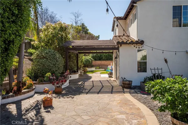 a view of a patio with couches table and chairs and potted plants