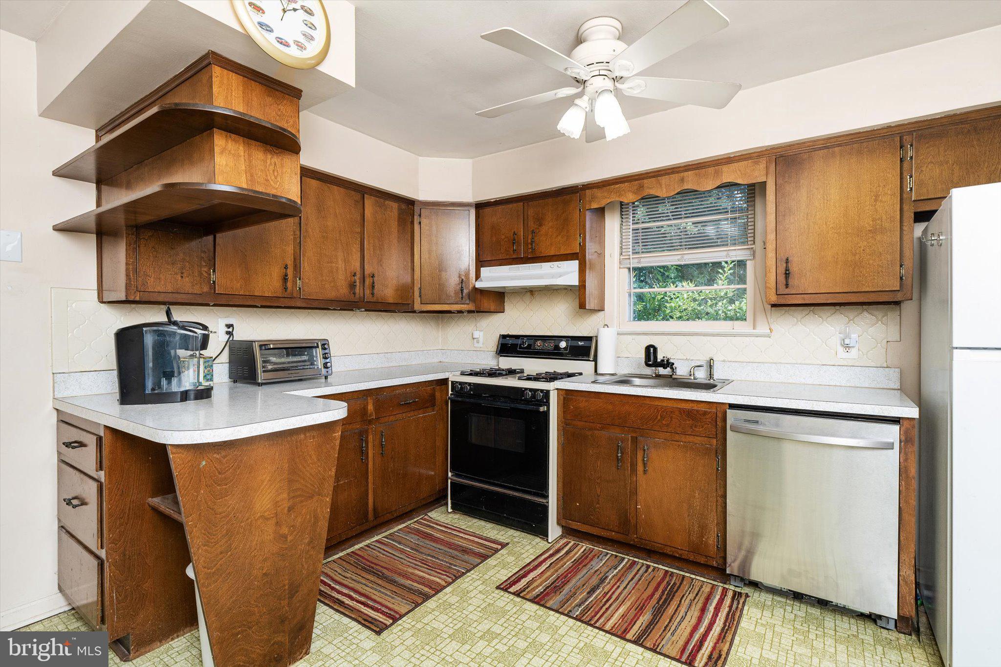 12 Fox Lane Hamilton, NJ 08620 - Photo 15 of 26 a kitchen with stainless steel appliances granite countertop a sink a stove a refrigerator cabinets and a dining table with wooden floor