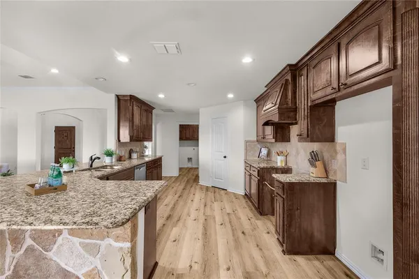 a kitchen with stainless steel appliances granite countertop a sink stove and refrigerator