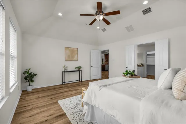 a bedroom with a bed chandelier and a window