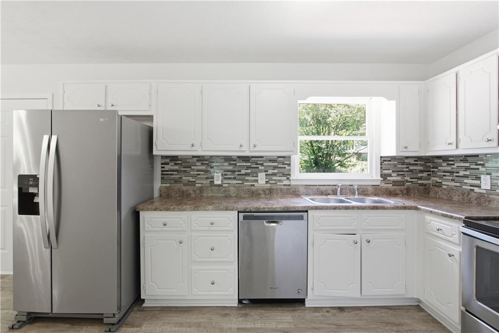 79 Cross Creek Court Villa Rica, GA 30180 - Photo 8 of 27 a kitchen with white cabinets white stainless steel appliances and sink