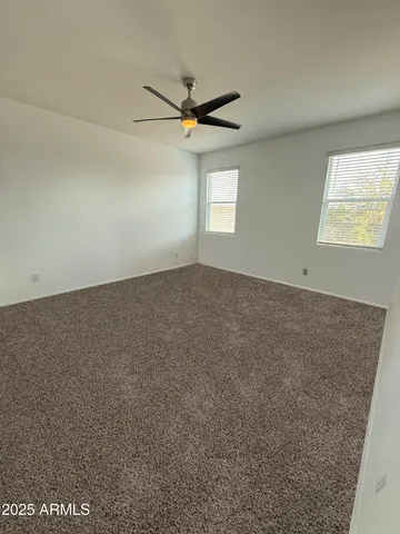 an empty room with windows and fan