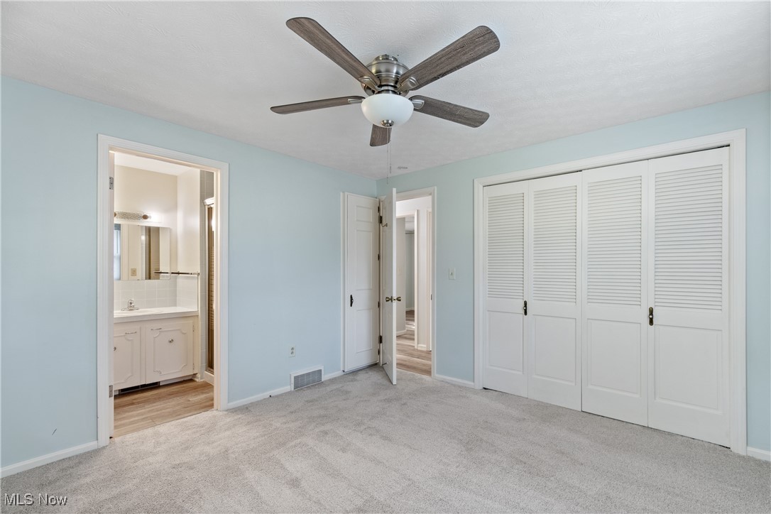 515 Oneida Avenue Northwest Canton, OH 44708 - Photo 14 of 28 Unfurnished bedroom with light colored carpet, a closet, a ceiling fan, and ensuite bath