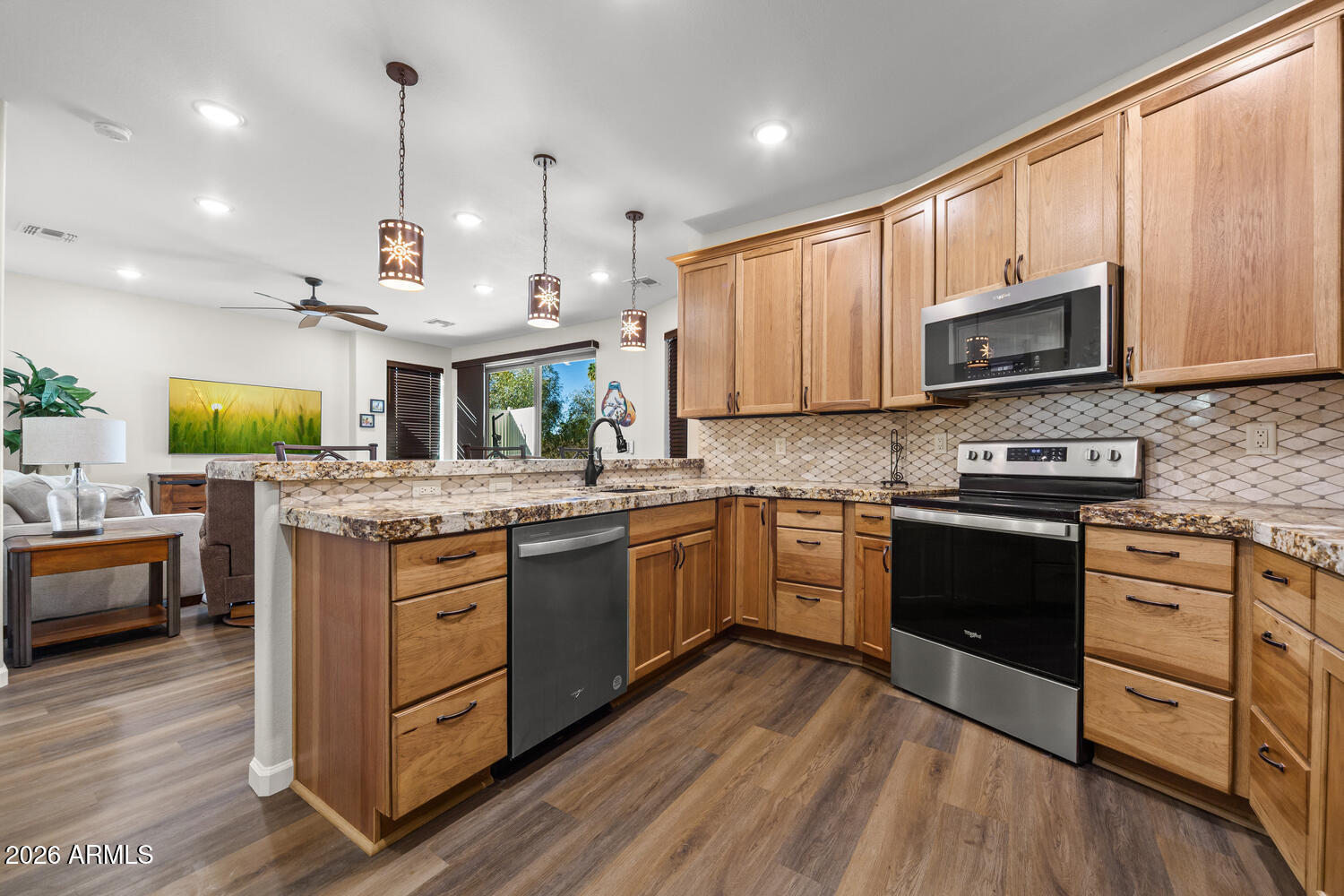 17200 West Bell Road, Unit 1054 Surprise, AZ 85374 - Photo 20 of 46 a kitchen with stainless steel appliances granite countertop wooden floors stove and cabinets