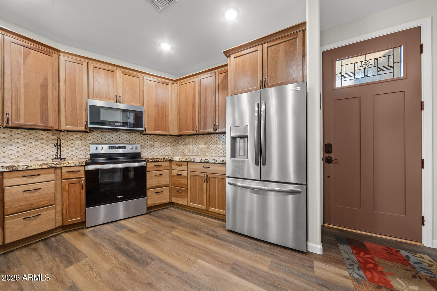 17200 West Bell Road, Unit 1054 Surprise, AZ 85374 - Photo 21 of 46 a kitchen with granite countertop wooden floors stainless steel appliances and a window
