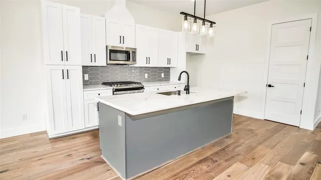 a kitchen with stainless steel appliances a sink stove and cabinets