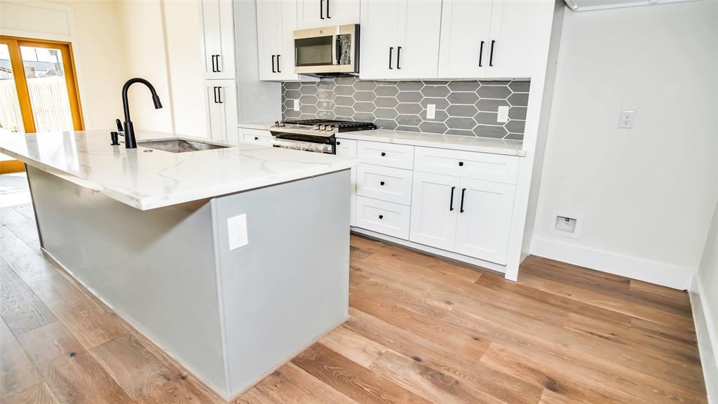 1508 Weiss Street Houston, TX 77009 - Photo 6 of 16 a kitchen with granite countertop a sink and a stove top oven