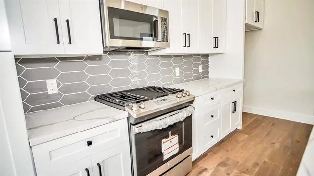 a kitchen with cabinets appliances and wooden floor