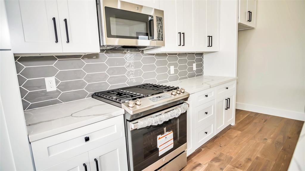 1508 Weiss Street Houston, TX 77009 - Photo 7 of 16 a kitchen with cabinets appliances and wooden floor