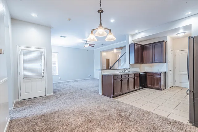a kitchen with kitchen island granite countertop a sink stove and refrigerator