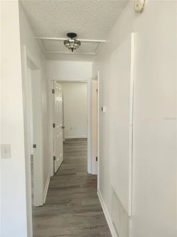 a view of a hallway with wooden floor