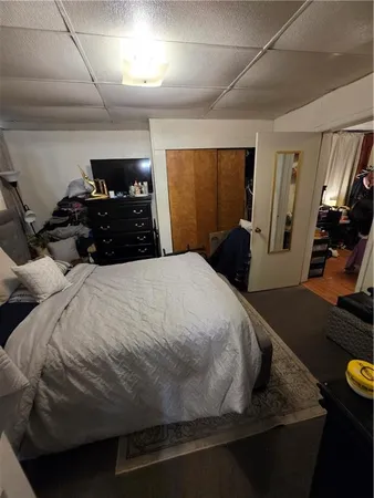 a bedroom with a bed and a flat tv screen