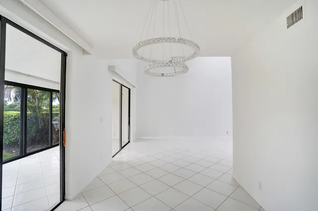 an empty room with wooden floor cabinet and windows