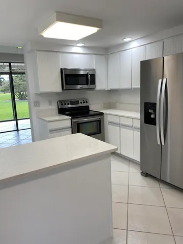 a kitchen with stainless steel appliances a refrigerator sink and microwave