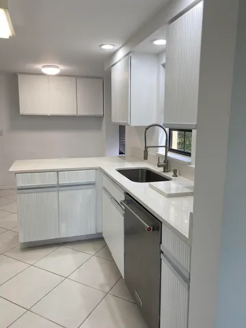 a kitchen with a sink cabinets and appliances