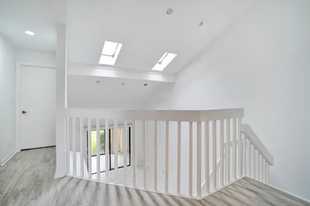 a view of a hallway with wooden floor
