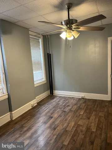en empty room with window and wooden floor