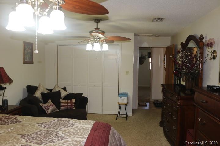 1949 Huckleberry Ridge Road Hiddenite, NC 28636 - Photo 22 of 31 a bed room with a bed mirror and a chandelier